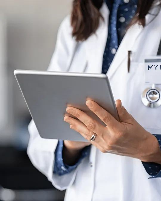 Praticienne My Laser en blouse blanche préparant un devis sur tablette pendant une consultation